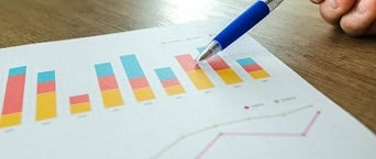 Canva - Man Showing Business Graph on Wood Table-1