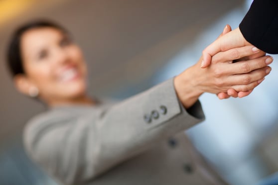 Welcoming business woman giving a handshake and smiling-1