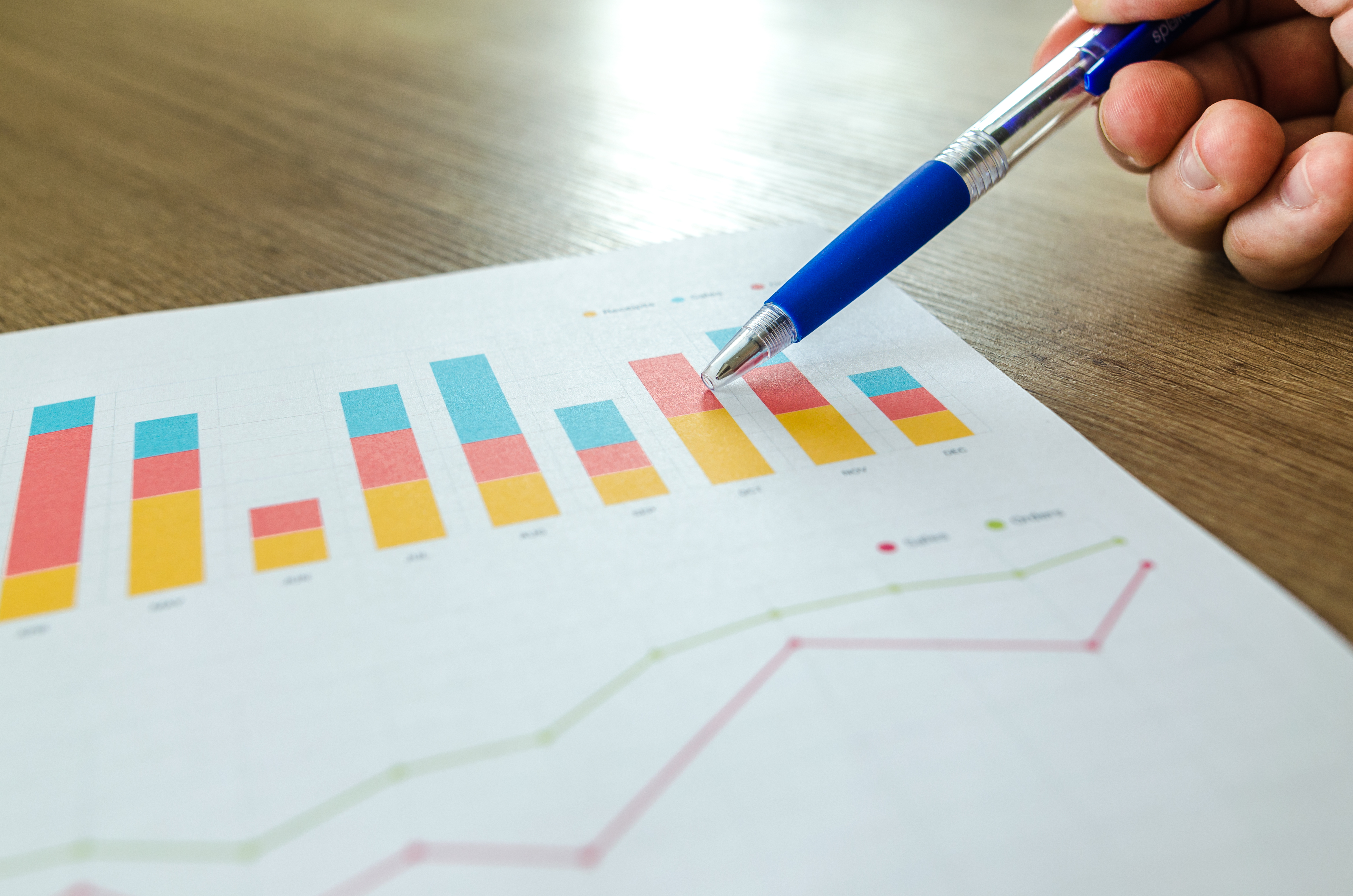 Canva - Man Showing Business Graph on Wood Table